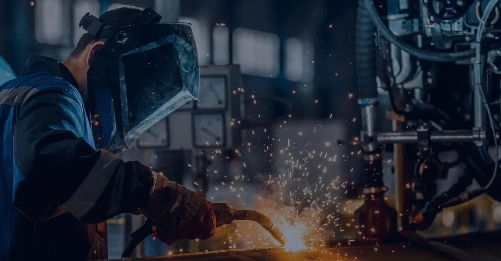 Welder at work in a factory, sparks flying